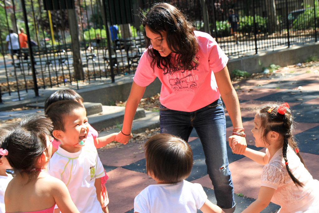 A playmaker creates a circle holding hands with kids