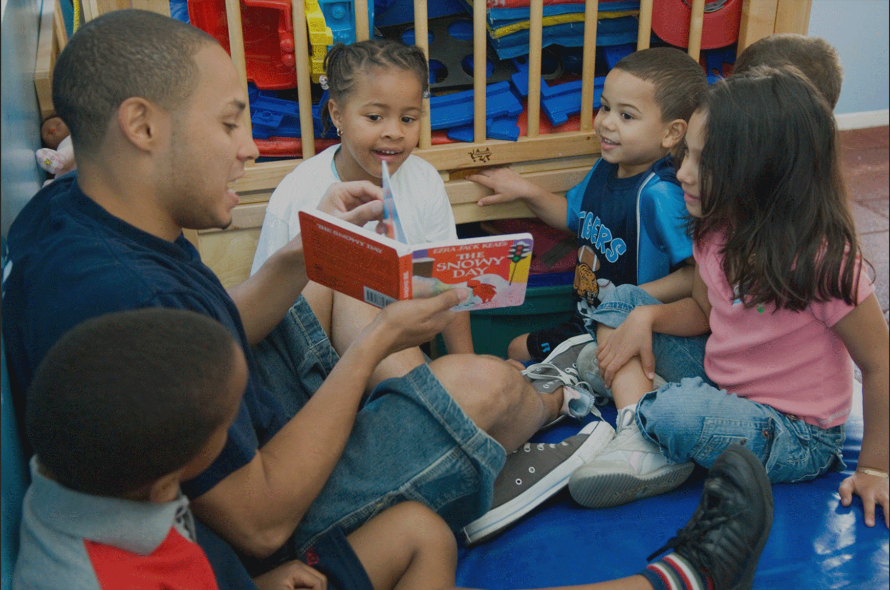 Playmaker reads a story to children