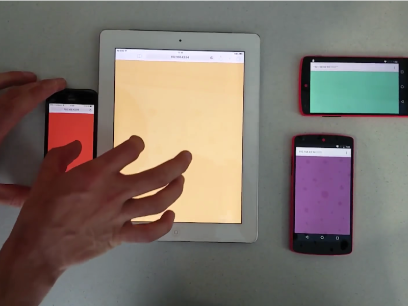 
              multiple smartphones and one tablet are placed on a table, a person performs a pinch gesture over two
              devices which are placed besides each others
            