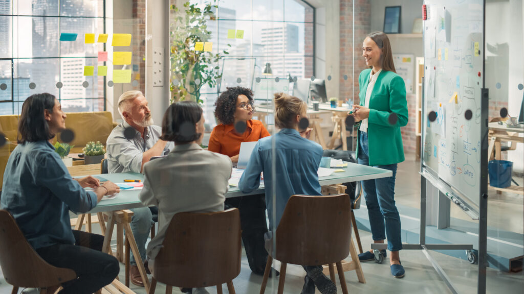 Young woman pitching to colleagues in office setting