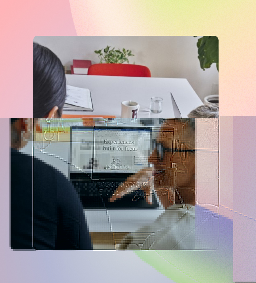 Two professionals, one with short gray hair and another with long black hair, are smiling and discussing a presentation on a laptop in a modern office setting.