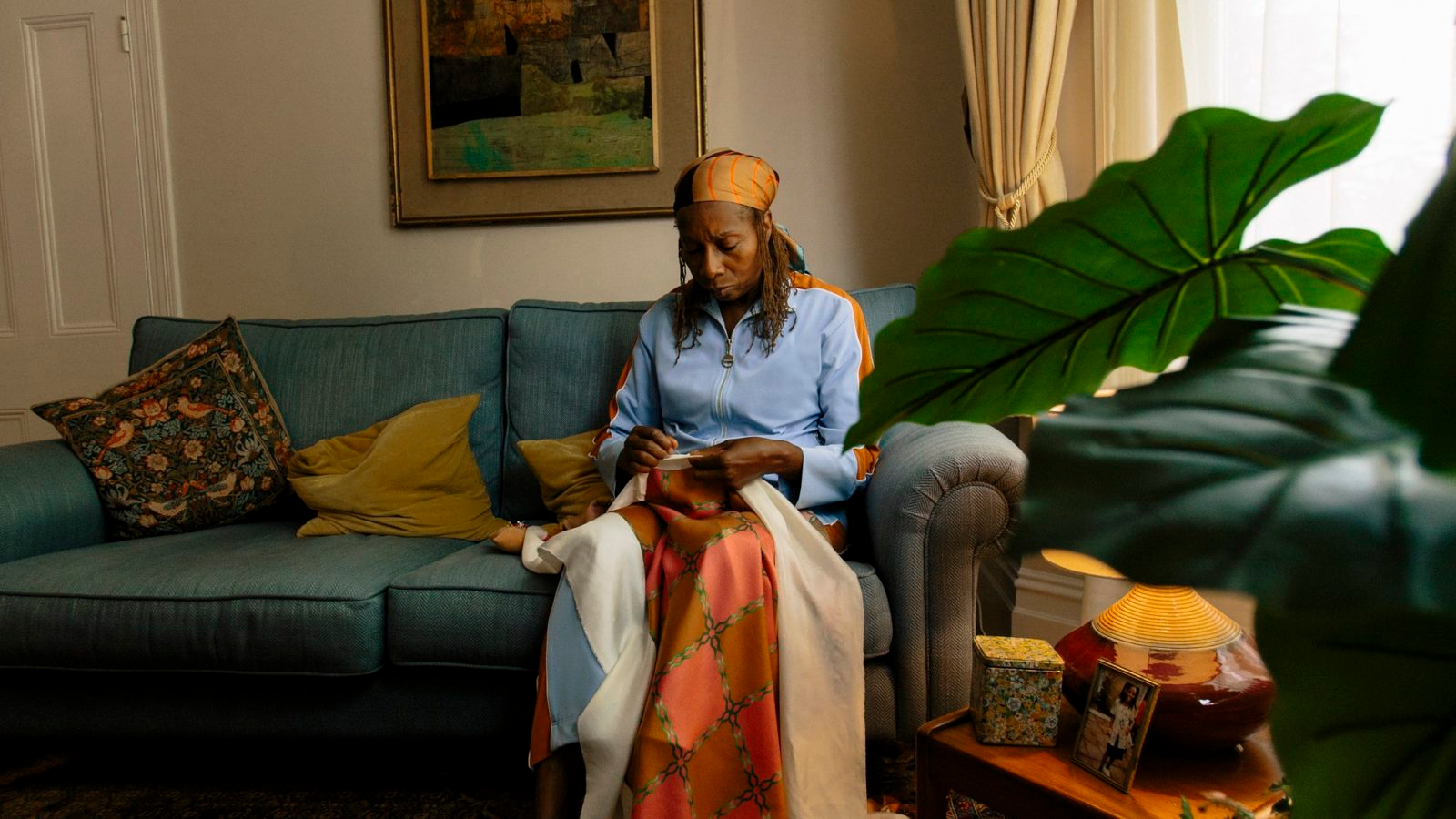 Ahluwalia sewing while sitting on couch