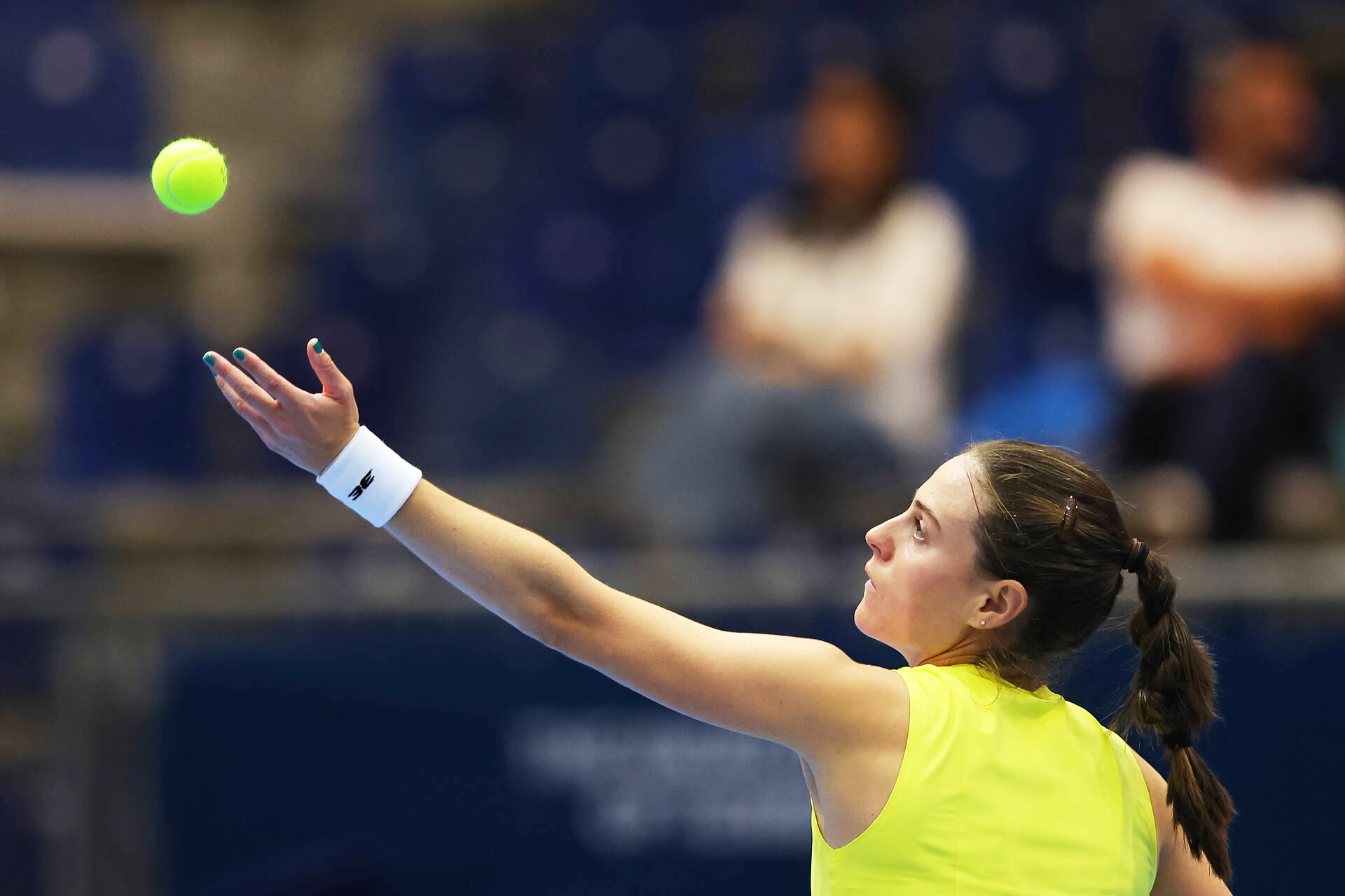 Female tennis player preparing to serve the ball during a match.