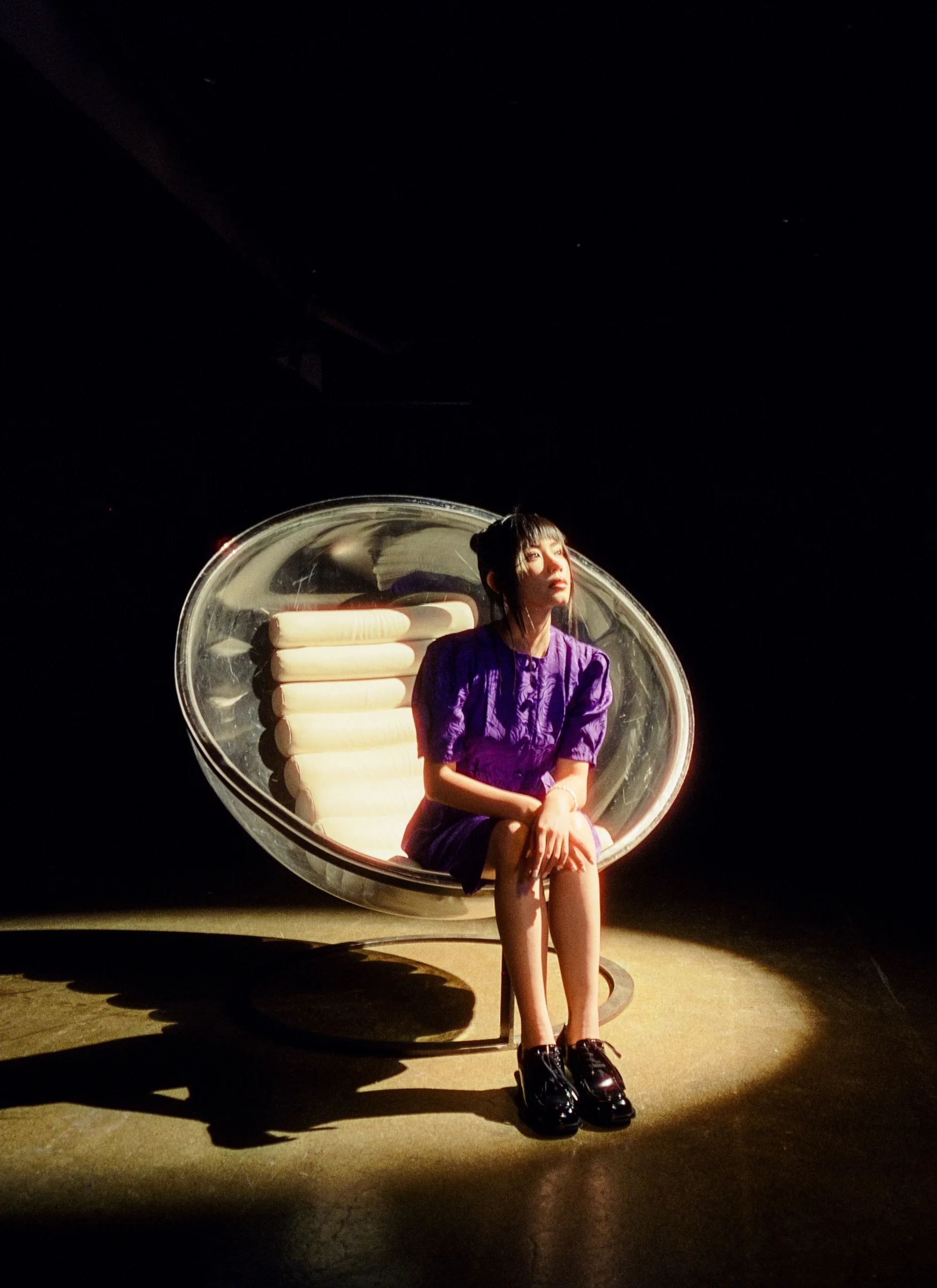 A woman sitting on a chair in a dark room.