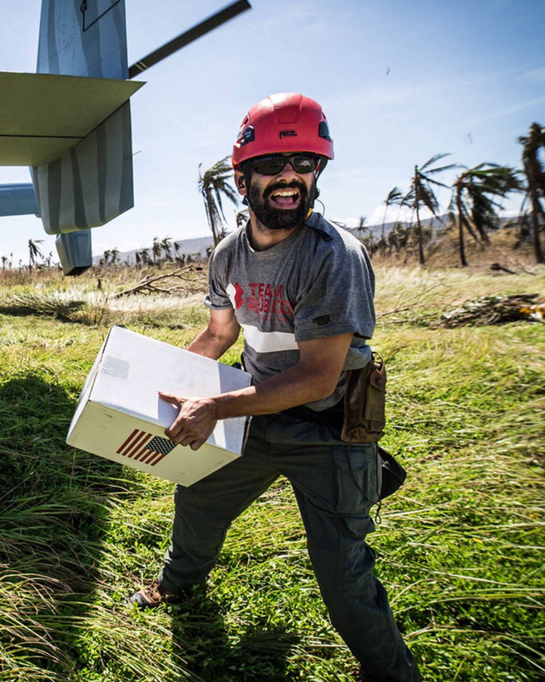 A man holding a box in front of a plane.