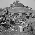 The crew of a Sherman tank receives rations before the start of Operation 'Totalise', 7 August 1944.