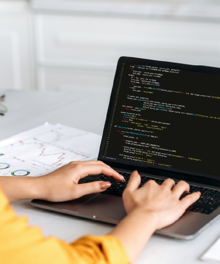 A woman uses her computer after learning the answer to the question, "What is a computer driver?"