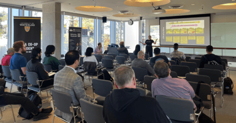 View of the presenter speaking to attendees during the mining event