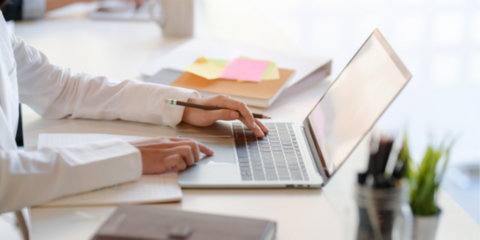 Employer writing a job description on a laptop