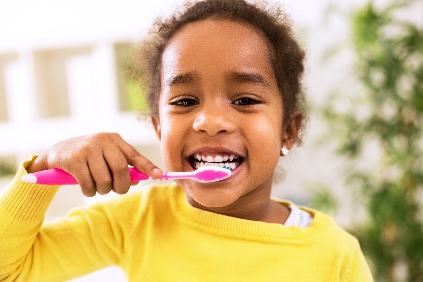 Young child brushing her teeth