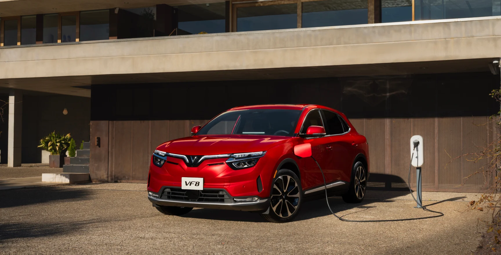 A red VF 8, from the new electric car company VinFast, drives down the highway