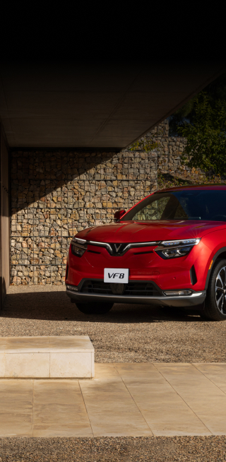 A red VF 8, from the new electric car company VinFast, drives down the highway