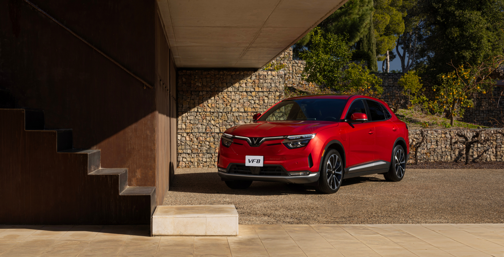 A red VF 8, from the new electric car company VinFast, drives down the highway