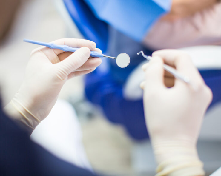 POV shot of male dentist with dental tools in hand. Dentist at work with surgical gloves and tools in hand.