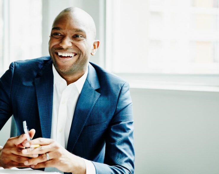 Smiling businessman in discussion at workstation in office