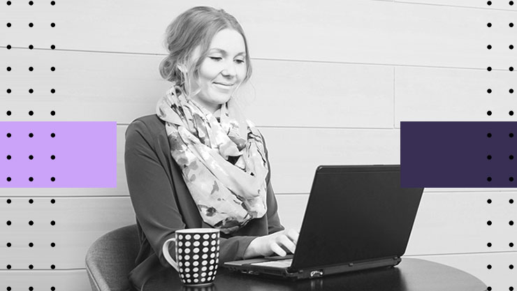 smiling woman works on her laptop