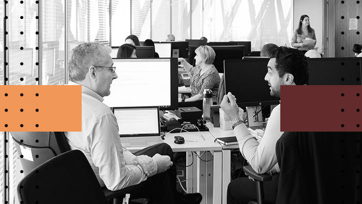 Two colleagues having a conversation in a shared office