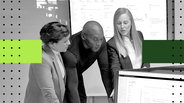 A group of colleagues looking at a monitor in an office setting