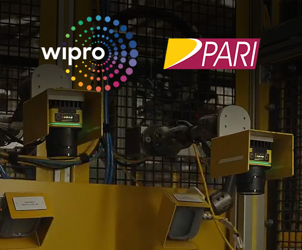 El logotipo de Wipro PARI y un lector de códigos de barras portátil Cognex incorporado en un panel de control de fabricación.