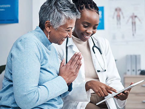 an elderly woman with a medical professional checking iPad