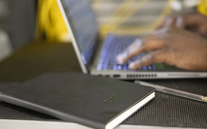 While this man works, his notebook sits beside him