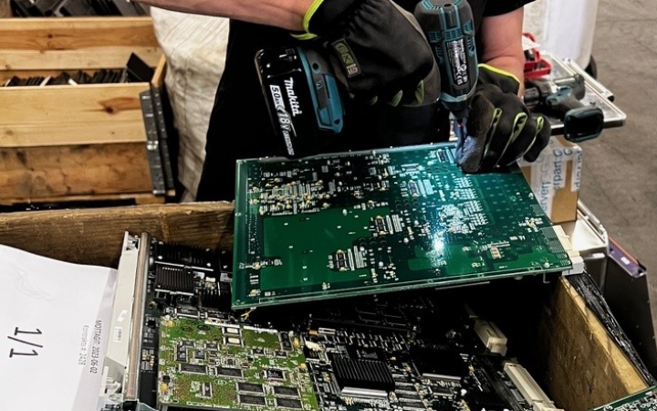 Man taking apart network equipment to recycle