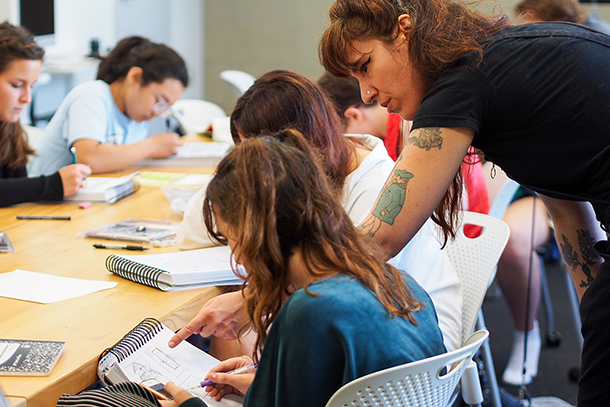 students working at large table in classroom