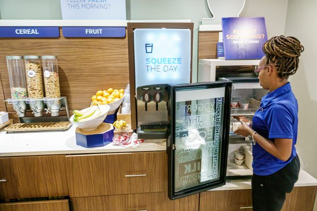 Worker reloads fridge in hotel