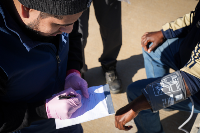 Medical assistant in gloves writes on notepad