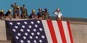 Photo of emergency responders and U.S. military soldiers hanging U.S. flag at top of Pentagon.