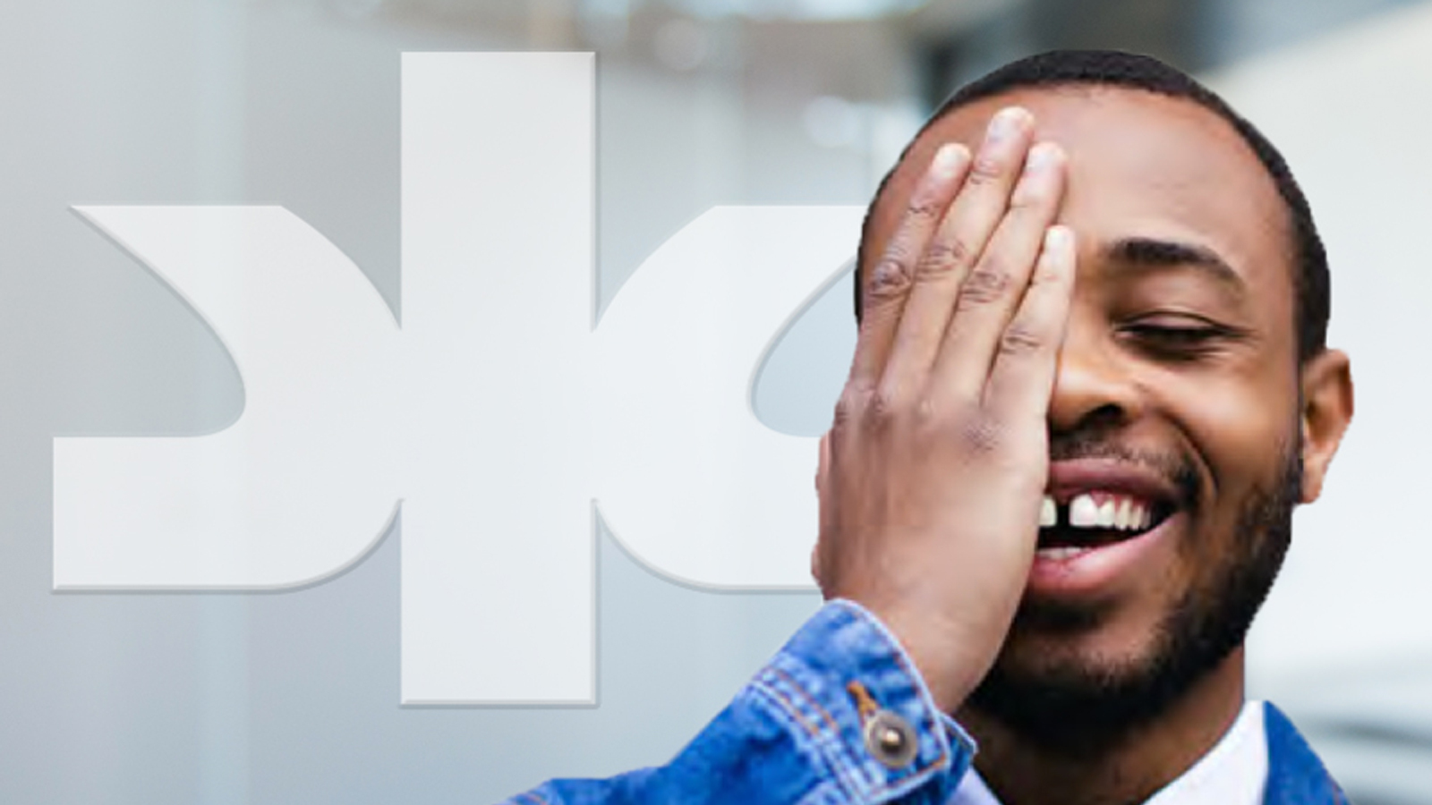 African American man laughing with hand covering right eye and white Kimberly-Clark logo in background