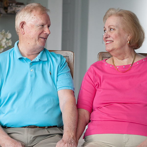 caucasian male and female holding hands while sitting in chairs