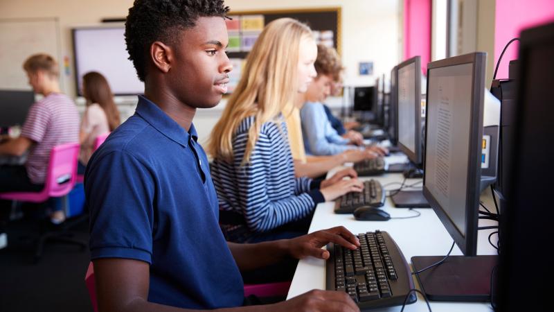 Teenager boy and classmates in high school computer class