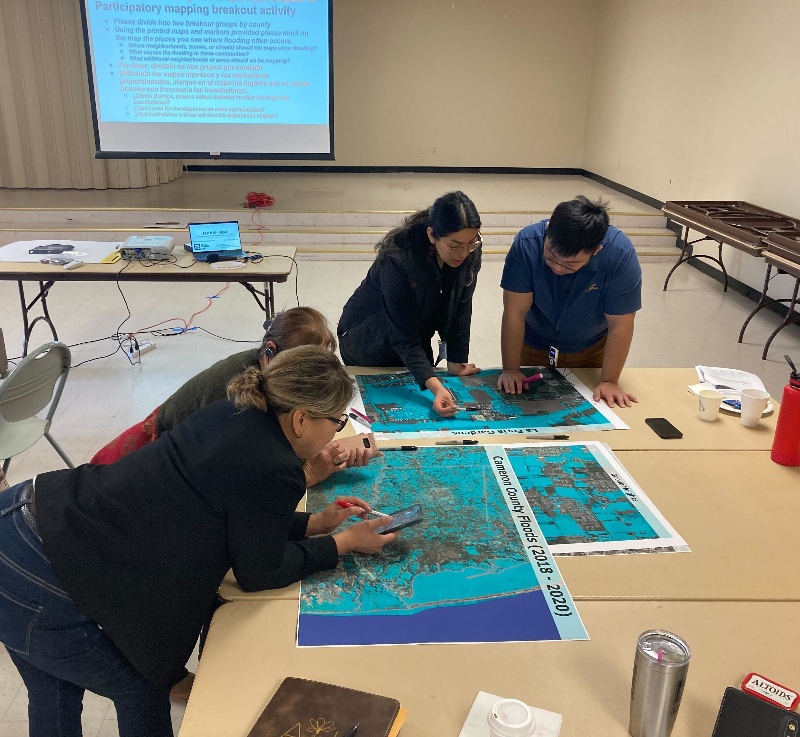 Researchers reviewing a draft flood map and discussing colonias in Cameron County that experienced flooding, as part of a workshop involving community partners.