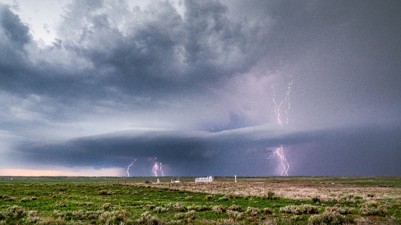 A supercell thunderstorm dominates the sky over the Texas Panhandle, displaying rotating clouds and lightning activity.