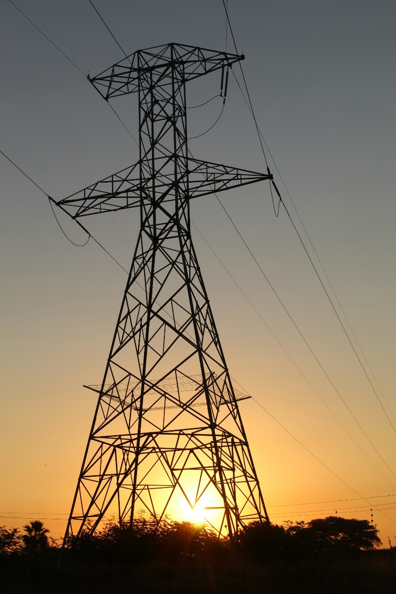 Silhouette of power lines against a colorful sunset sky