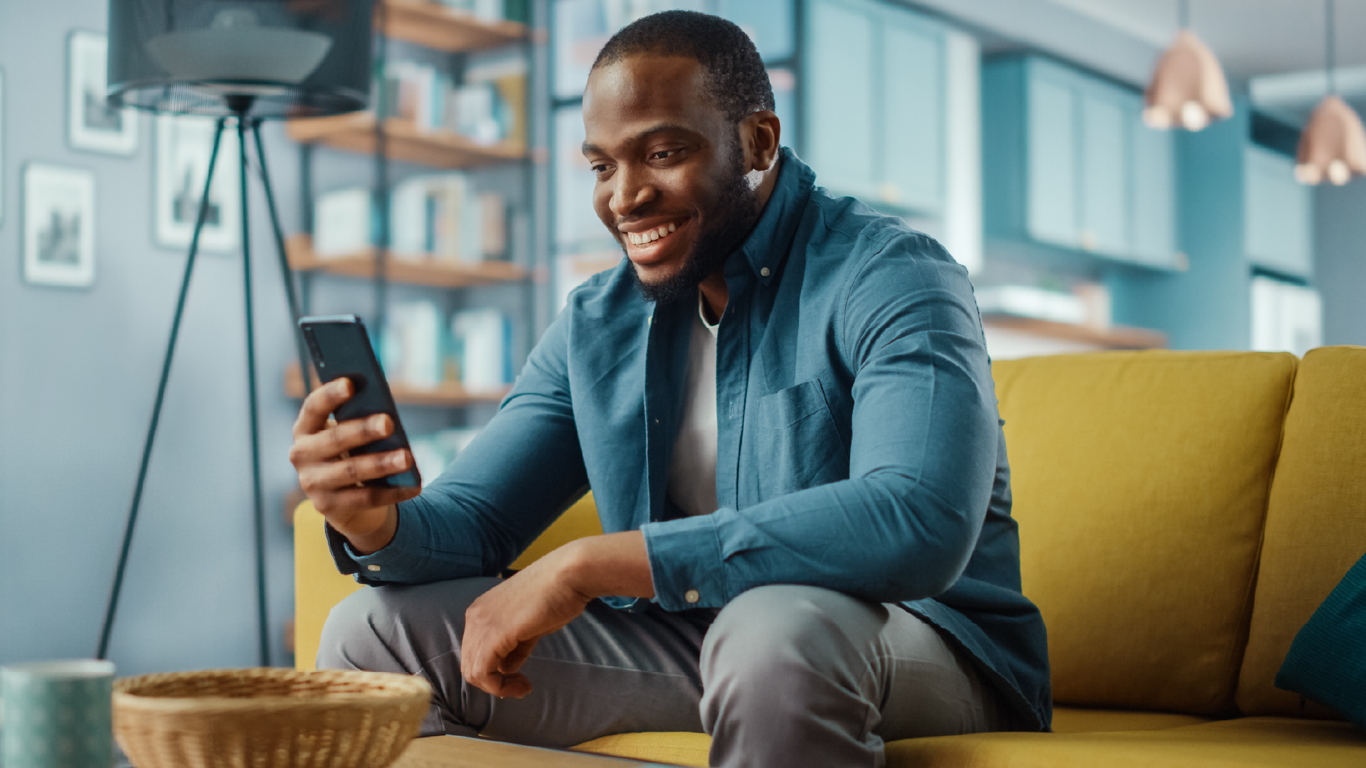 man on couch looking at phone