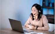 woman with headset while on their laptop