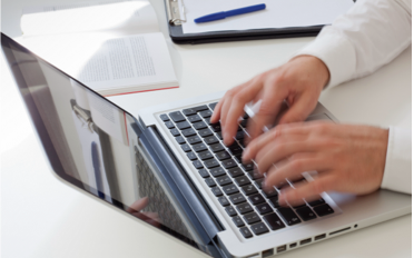 hands typing on laptop