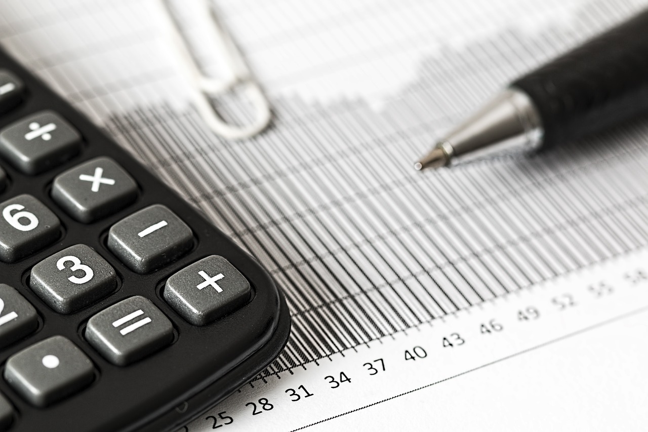 a close up of part of a calculator laying on a spreadsheet with a pencil next to it.