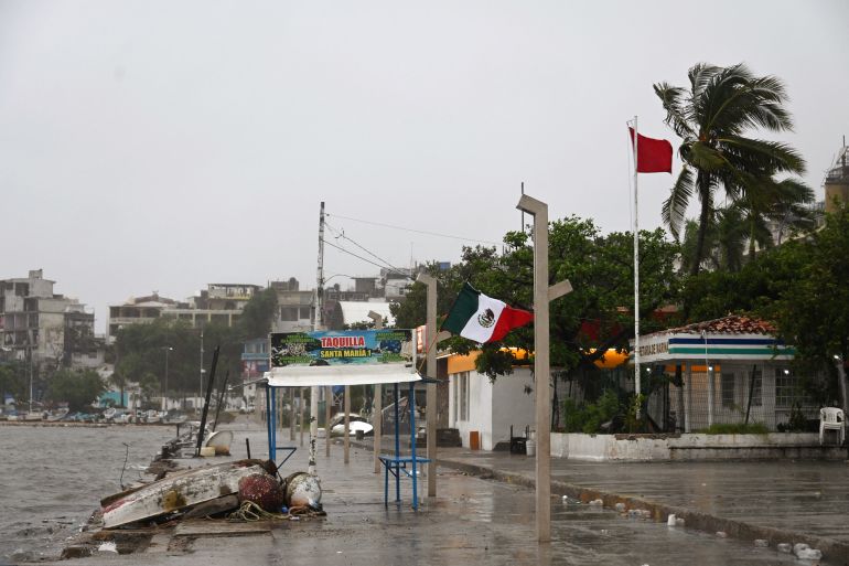 A Mexican flag is pictured under the rain after the passage of hurricane John in Acapulco, Mexico