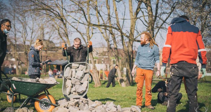 Photo d'un groupe en train de travailler en déplaçant des blocs de pierre pour le projet "A place to-be-come".