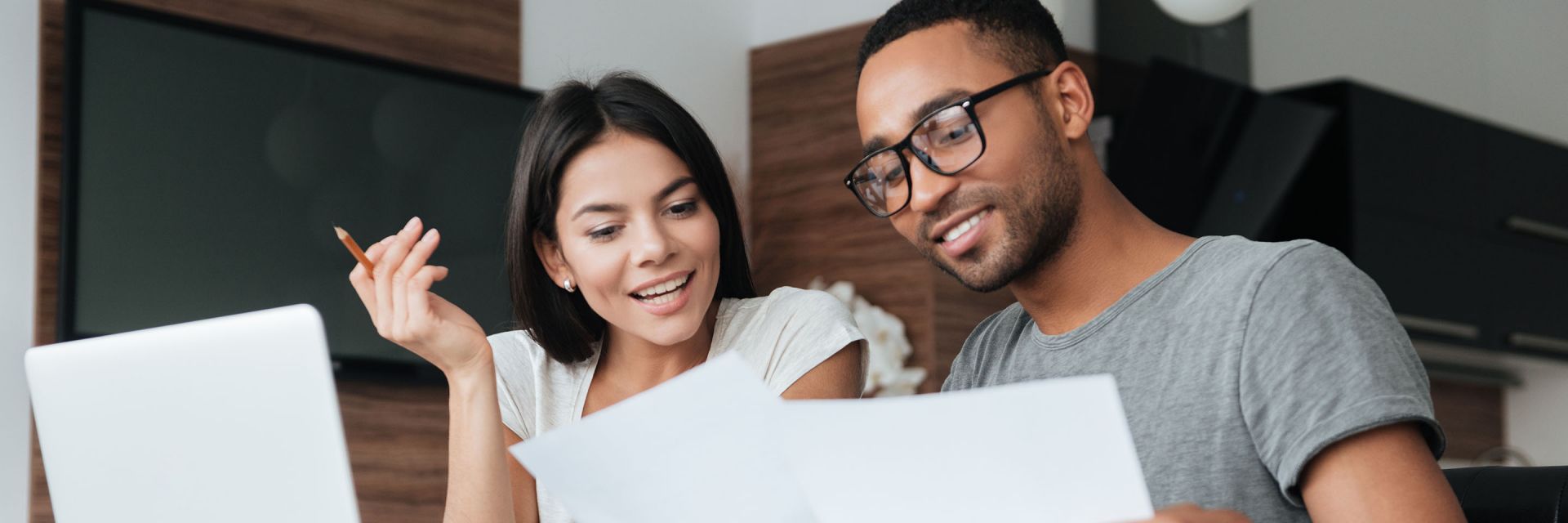 A couple sitting at a table looking at papers together