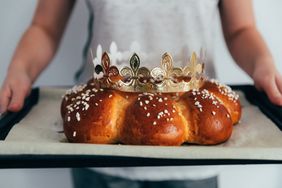 child holding tray with freshly baked king bread for Three Kings Day celebrations