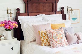 bed with throw pillows and dark wood headboard