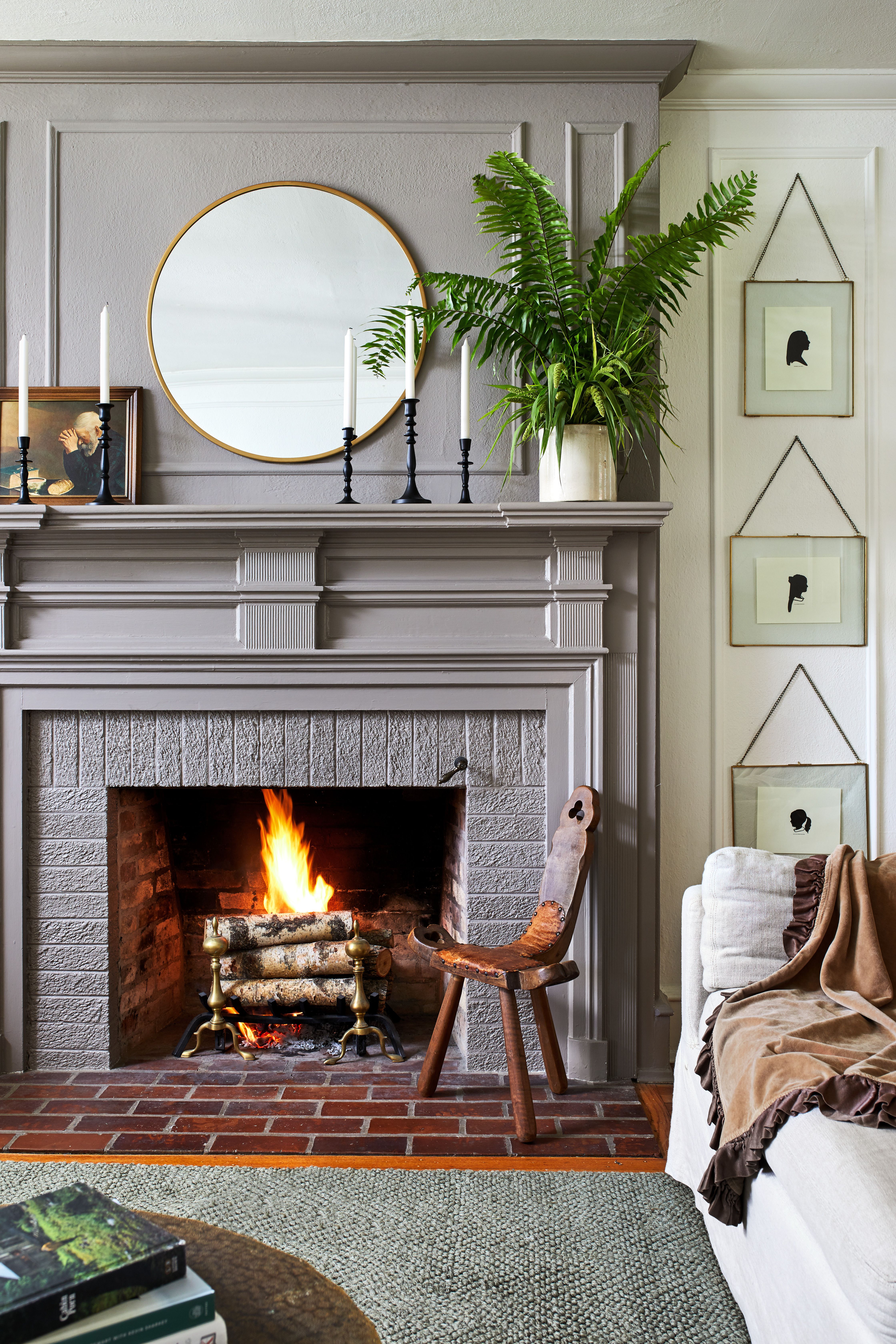 a gray fireplace with a mirror and candles