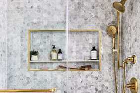 gray bathroom shower with gold faucet