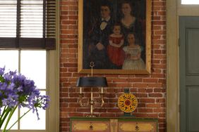 brick wall with wood dresser and gold frame artwork