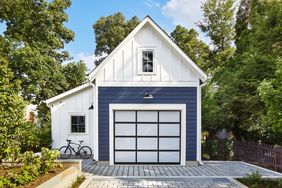 sunny exterior photo of blue and white garage with black grid design