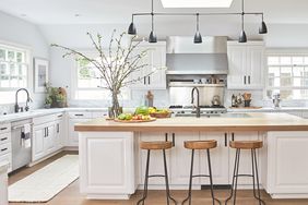 large white kitchen with island and wood flooring